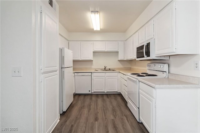kitchen with white appliances, a sink, dark wood-style flooring, white cabinets, and light countertops