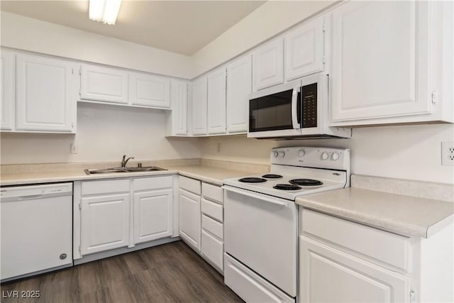 kitchen featuring white appliances, a sink, and white cabinetry