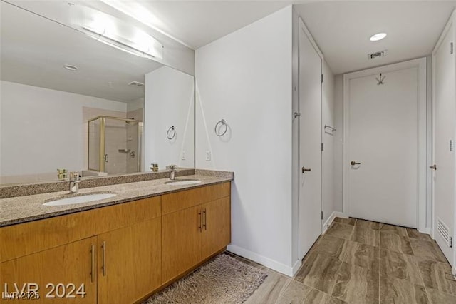 bathroom featuring a stall shower and double vanity