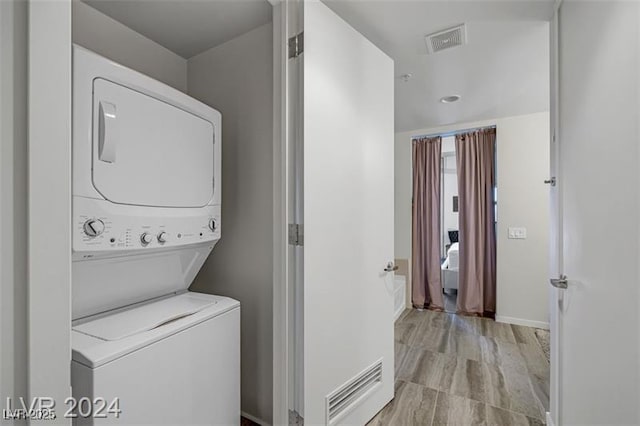 laundry room featuring estacked washer and dryer and baseboards