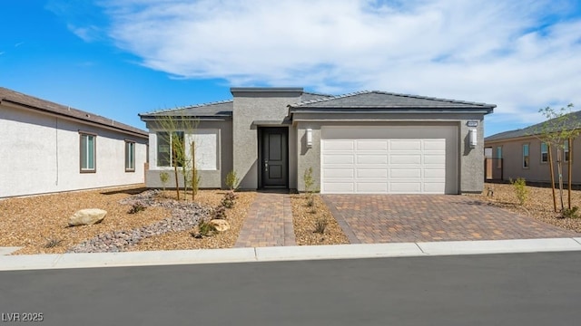 4410 E Brusca Way, Pahrump, NV 89061 - ranch-style house featuring an attached garage, decorative driveway, stucco siding, and a tile roof