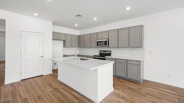 4410 E Brusca Way, Pahrump, NV 89061 - kitchen featuring appliances with stainless steel finishes, gray cabinetry, a sink, wood finished floors, and recessed lighting
