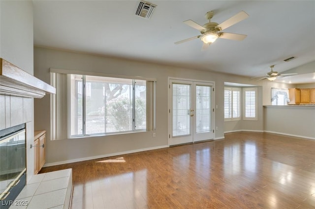 10009 Netherton Dr, Las Vegas, NV 89134 - unfurnished living room with a ceiling fan, a tiled fireplace, wood finished floors, and baseboards