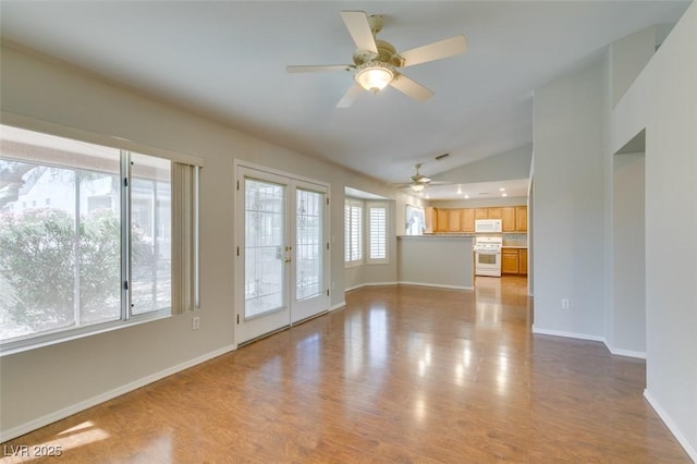 10009 Netherton Dr, Las Vegas, NV 89134 - unfurnished living room featuring ceiling fan, vaulted ceiling, light wood-style flooring, and baseboards