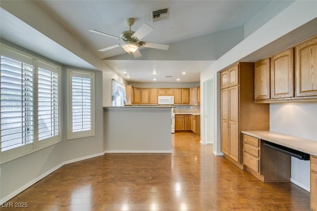 10009 Netherton Dr, Las Vegas, NV 89134 - kitchen with white microwave, ceiling fan, backsplash, wood finished floors, and light countertops