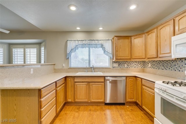10009 Netherton Dr, Las Vegas, NV 89134 - kitchen featuring white appliances, a sink, light countertops, light wood finished floors, and recessed lighting