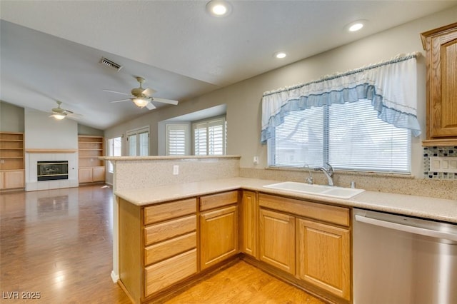 10009 Netherton Dr, Las Vegas, NV 89134 - kitchen featuring stainless steel dishwasher, a sink, a ceiling fan, vaulted ceiling, and light wood-type flooring
