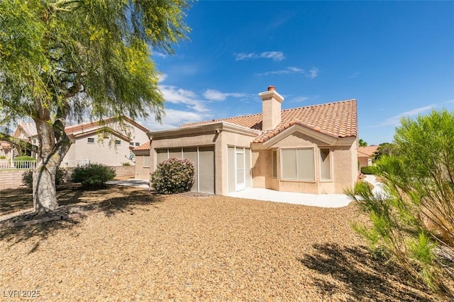 10009 Netherton Dr, Las Vegas, NV 89134 - rear view of house featuring a chimney, a tile roof, stucco siding, and fence