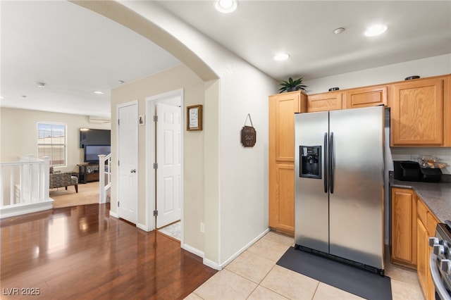 6488 Bentley Wood Ct, Las Vegas, NV 89130 - kitchen with stainless steel appliances, arched walkways, dark countertops, recessed lighting, and baseboards