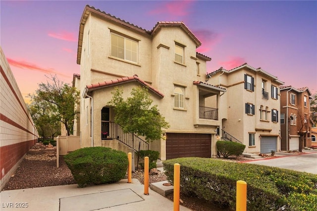6488 Bentley Wood Ct, Las Vegas, NV 89130 - view of front facade with a tiled roof, stucco siding, a garage, and a balcony
