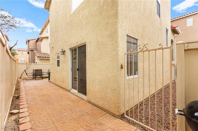 6488 Bentley Wood Ct, Las Vegas, NV 89130 - view of side of home featuring stucco siding, a patio area, and a fenced backyard