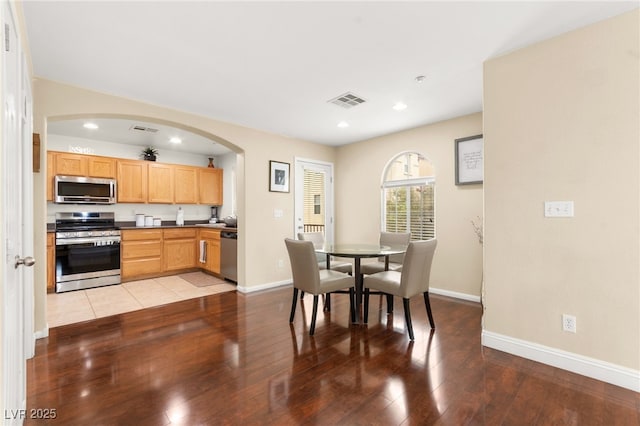 6488 Bentley Wood Ct, Las Vegas, NV 89130 - dining area featuring recessed lighting, arched walkways, light wood-style flooring, and baseboards