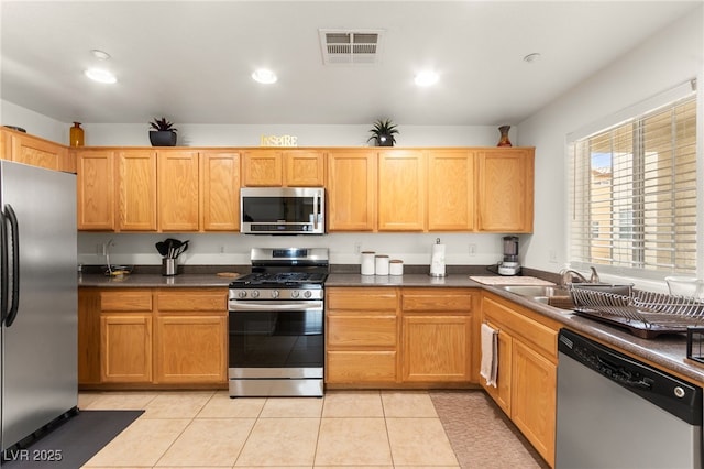 6488 Bentley Wood Ct, Las Vegas, NV 89130 - kitchen featuring stainless steel appliances, recessed lighting, dark countertops, light tile patterned floors, and a sink