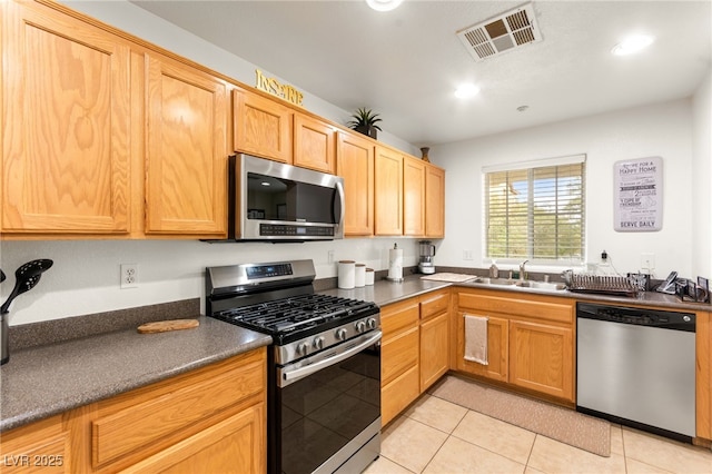 6488 Bentley Wood Ct, Las Vegas, NV 89130 - kitchen featuring appliances with stainless steel finishes, a sink, dark countertops, light tile patterned flooring, and recessed lighting