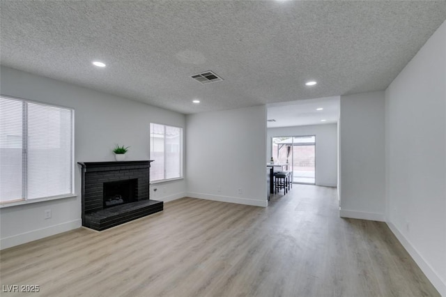1744 La Cruz Dr, Henderson, NV 89014 - unfurnished living room with wood finished floors, a textured ceiling, recessed lighting, a fireplace, and baseboards