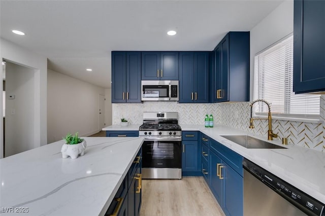 1744 La Cruz Dr, Henderson, NV 89014 - kitchen featuring stainless steel appliances, blue cabinets, a sink, light wood-style floors, and light stone countertops