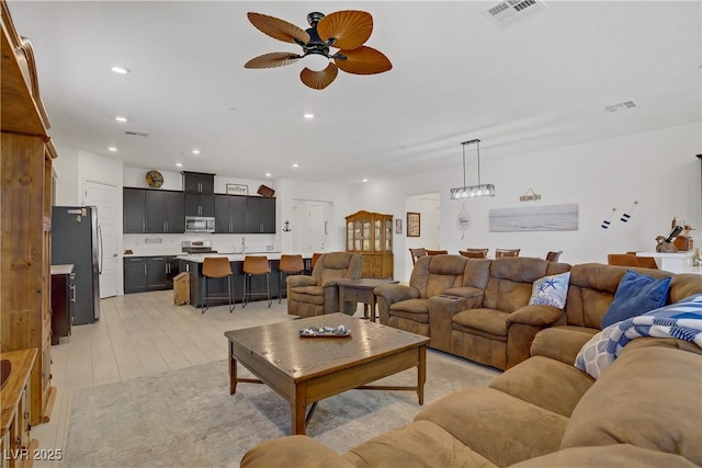 709 Corelli Cove St, Henderson, NV 89011 - living room with a ceiling fan, recessed lighting, a chandelier, and light wood finished floors