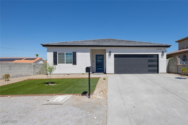 view of front of home featuring an attached garage, concrete driveway, and stucco siding