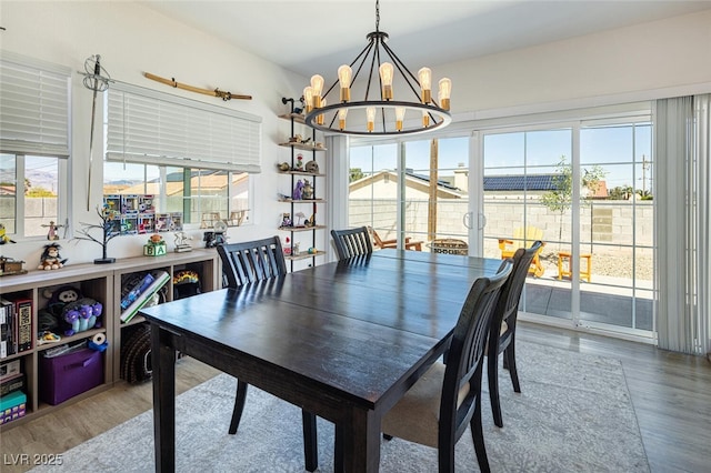 dining space featuring wood finished floors and a chandelier