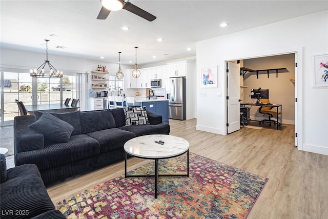 living area featuring ceiling fan, an office area, recessed lighting, a chandelier, and light wood-style floors