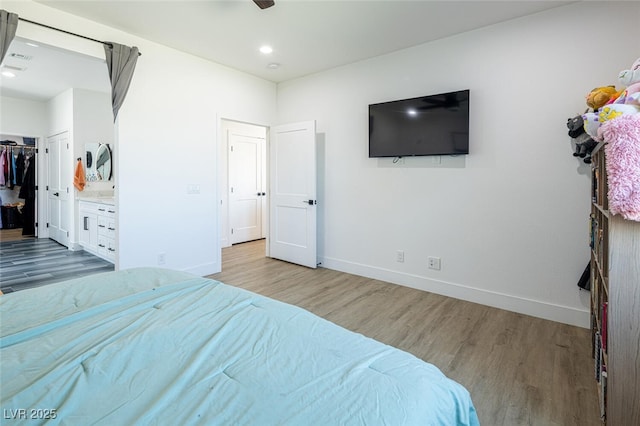 bedroom featuring wood finished floors, baseboards, recessed lighting, a closet, and a walk in closet