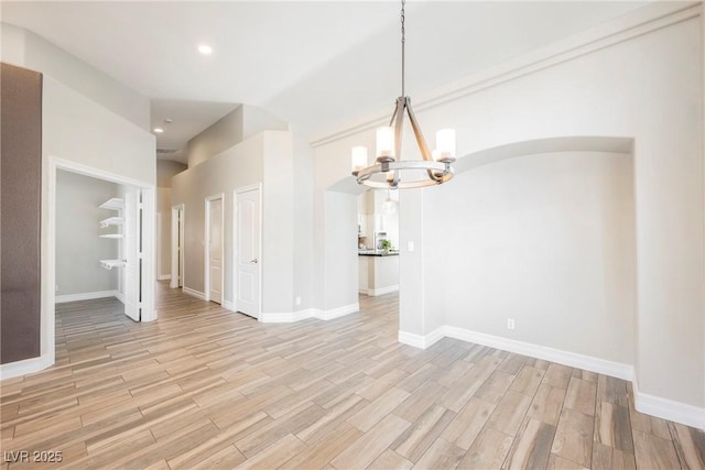 3882 Genoa Dr, Las Vegas, NV 89141 - unfurnished dining area featuring a chandelier, arched walkways, light wood finished floors, baseboards, and recessed lighting