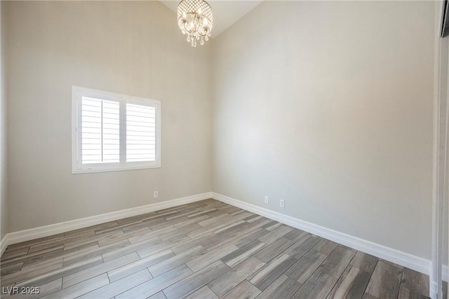 3882 Genoa Dr, Las Vegas, NV 89141 - empty room featuring a chandelier, wood finished floors, and baseboards