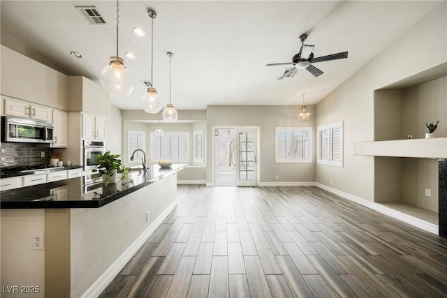 3882 Genoa Dr, Las Vegas, NV 89141 - kitchen featuring stainless steel appliances, lofted ceiling, healthy amount of natural light, baseboards, and dark wood-type flooring