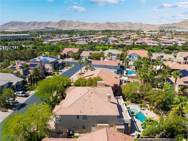 aerial perspective of suburban area with a pool area and a mountain backdrop