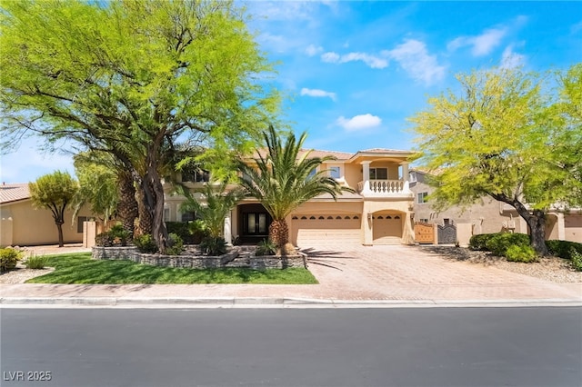 mediterranean / spanish house featuring a balcony, stucco siding, driveway, and a garage