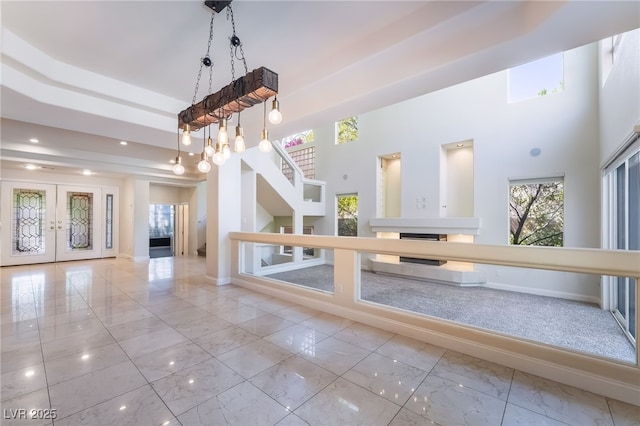 entrance foyer featuring marble look tiles, french doors, baseboards, a towering ceiling, and recessed lighting