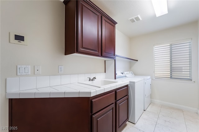laundry room with cabinet space, washer and dryer, light marble finish floors, and baseboards