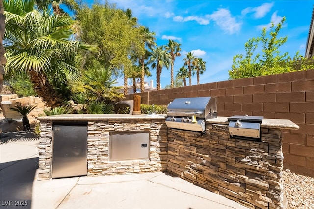 view of patio featuring area for grilling and fence