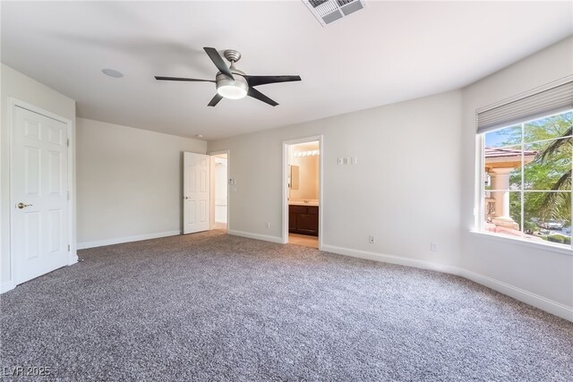 unfurnished bedroom featuring carpet floors, baseboards, connected bathroom, and a ceiling fan