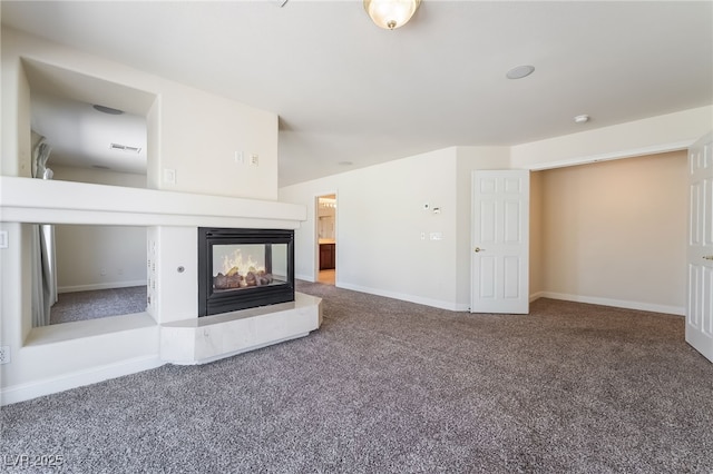 unfurnished living room featuring carpet, a multi sided fireplace, and baseboards