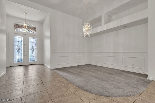 1532 Via Cassia, Henderson, NV 89052 - carpeted foyer with a chandelier, tile patterned floors, french doors, a decorative wall, and a towering ceiling