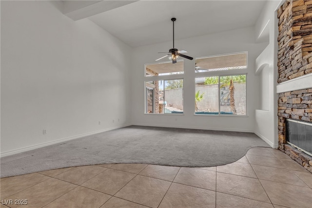 1532 Via Cassia, Henderson, NV 89052 - unfurnished living room featuring light carpet, light tile patterned flooring, a stone fireplace, ceiling fan, and baseboards