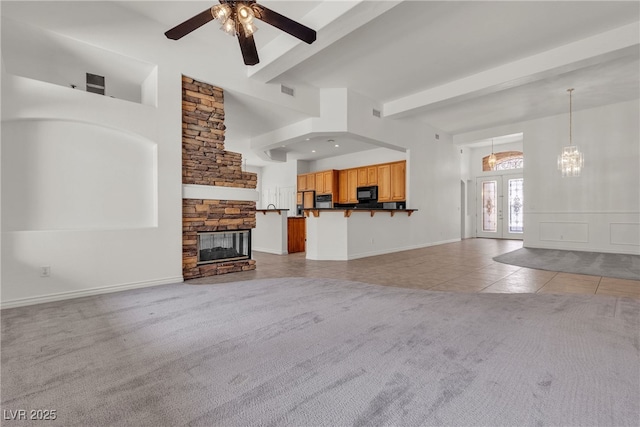 1532 Via Cassia, Henderson, NV 89052 - unfurnished living room featuring light tile patterned floors, beam ceiling, light colored carpet, a ceiling fan, and a fireplace