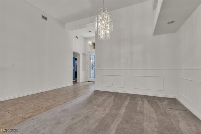 1532 Via Cassia, Henderson, NV 89052 - unfurnished dining area with arched walkways, tile patterned flooring, a chandelier, a high ceiling, and carpet floors