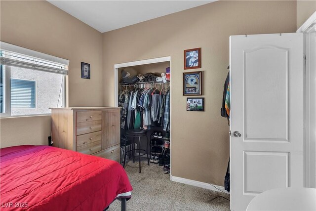 carpeted bedroom with a closet, baseboards, and a spacious closet