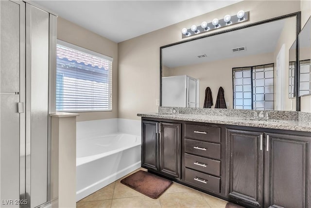 full bathroom featuring tile patterned floors, a garden tub, double vanity, and a shower stall