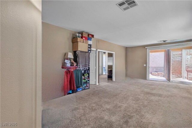 spare room featuring carpet flooring and a textured wall