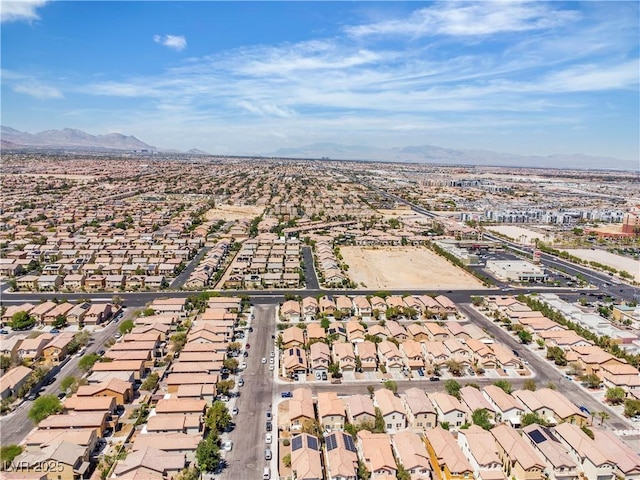 aerial view of property and surrounding area featuring nearby suburban area and a mountain backdrop