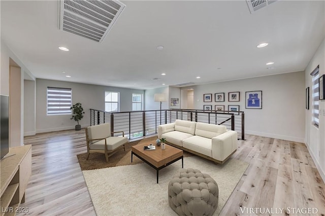 living room with light wood-style flooring, recessed lighting, and baseboards