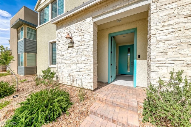 entrance to property featuring stone siding and stucco siding