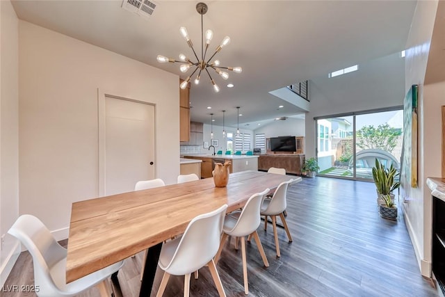 dining space featuring healthy amount of natural light, a chandelier, wood finished floors, baseboards, and recessed lighting