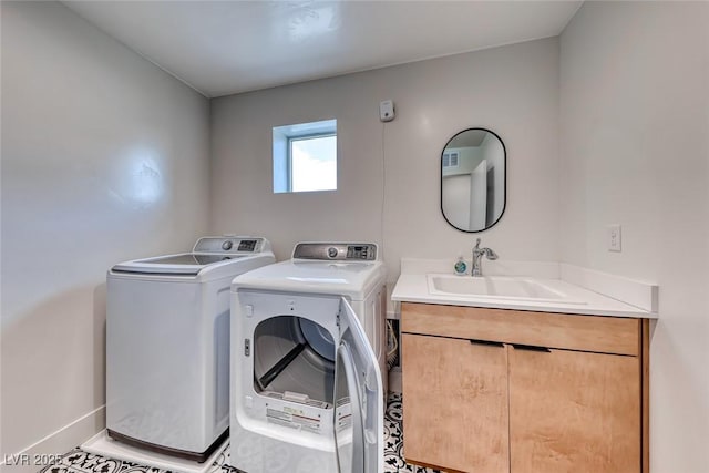 clothes washing area featuring cabinet space, washing machine and dryer, and baseboards