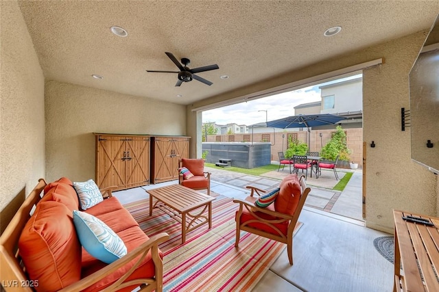 view of patio / terrace featuring a hot tub, an outdoor hangout area, ceiling fan, outdoor dining area, and fence