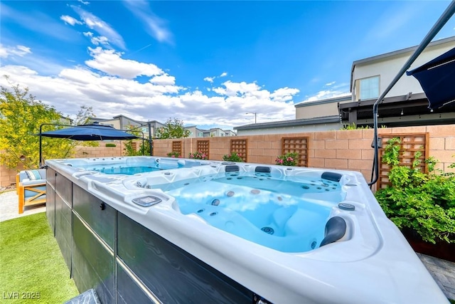 view of pool featuring a hot tub and fence