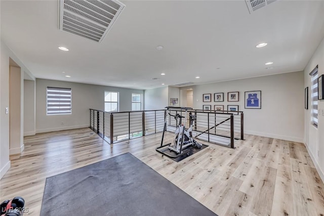 exercise room featuring wood finished floors, recessed lighting, and baseboards